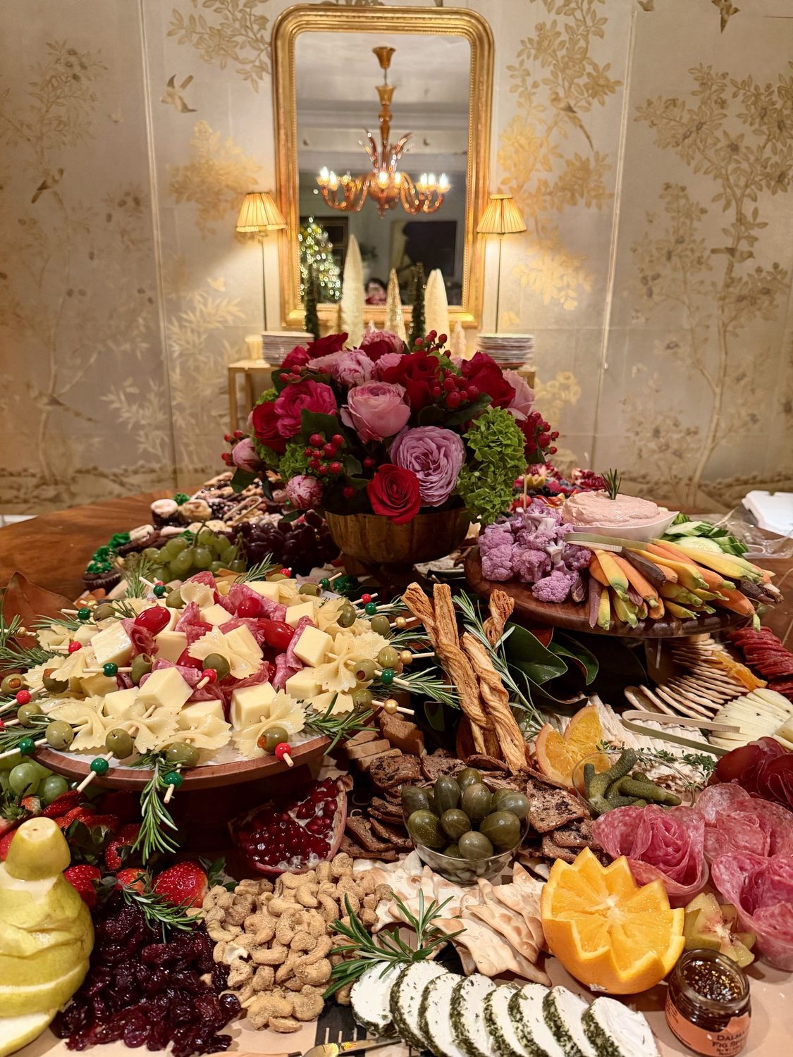 A styled grazing spread beneath a gilt mirror.